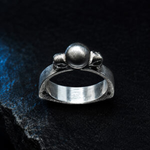 Anello triangolare in argento 925 con sfera centrale e teschi laterali — Plexibones